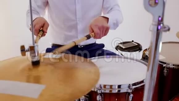 一个快乐的男子鼓手从音乐乐队演奏歌曲在录音室击中高帽视频的预览图