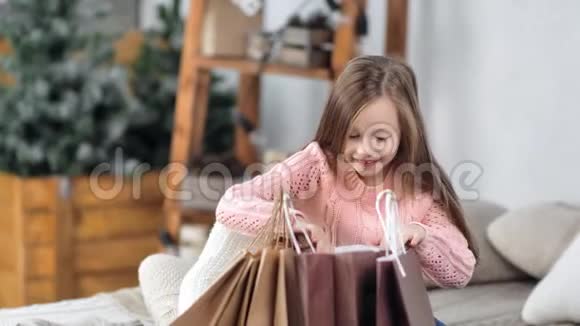 令人兴奋的小可爱女孩打开圣诞礼物包装袋得到金色闪光球视频的预览图