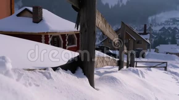 古老废弃的木栅栏和白雪皑皑的木屋和群山的冬季乡村景象视频的预览图