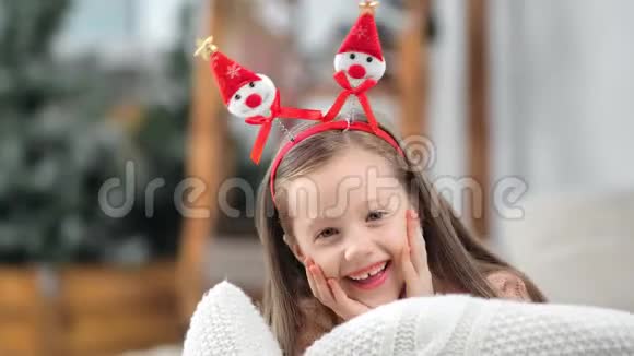 小女孩在滑稽的圣诞耳朵里摆姿势笑着积极的情绪的肖像视频的预览图