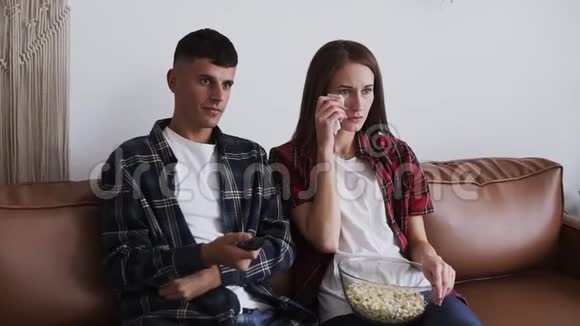 丈夫在家时敏感的女人正在看电视和哭泣男人换香奈儿夫妇坐在布朗视频的预览图