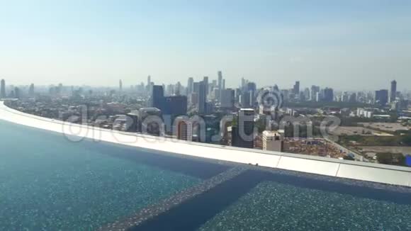 豪华公寓俯瞰城市天际线的屋顶蓝色游泳池视频的预览图