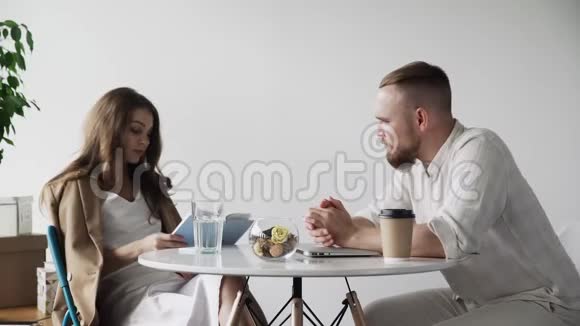 几个商人坐在咖啡馆里年轻夫妇正在讨论一本新书视频的预览图