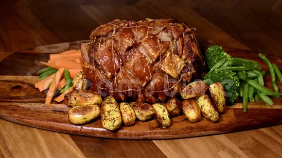 烤猪肉用肉饼和蔬菜装饰蒸汽从蔬菜中升起视频的预览图