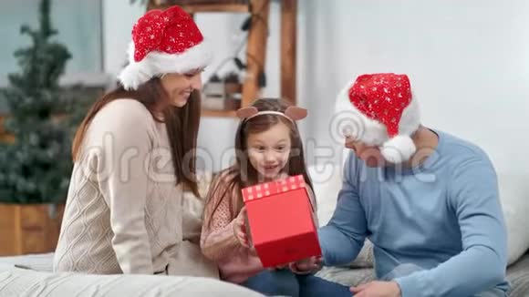 令人惊讶的小可爱女孩很高兴从父母那里得到圣诞礼物盒视频的预览图