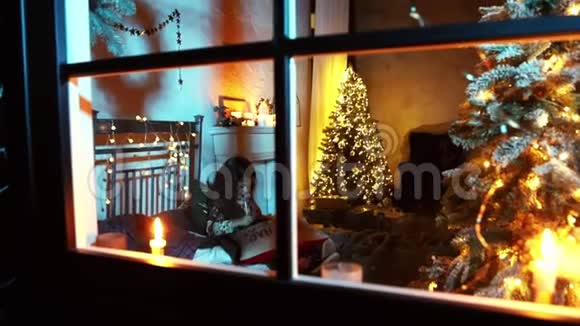 从窗户射进去小女孩在床上的圣诞树旁写信给圣诞老人圣诞和除夕视频的预览图