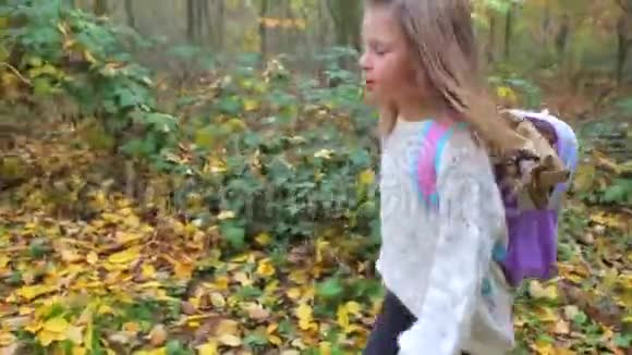 一个女孩走在秋林的路上视频的预览图
