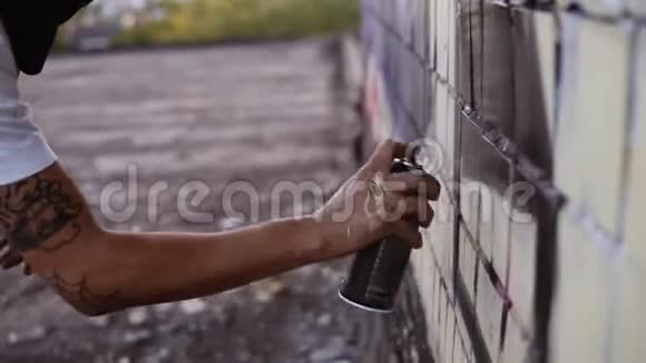 艺术家的特写在油漆中弄脏了在街道建筑墙上涂上了黑色的喷漆行动拘留视频的预览图