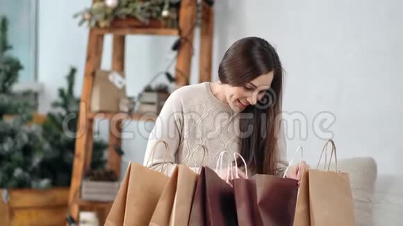 快乐休闲的年轻女子打开圣诞礼物的纸质购物袋视频的预览图