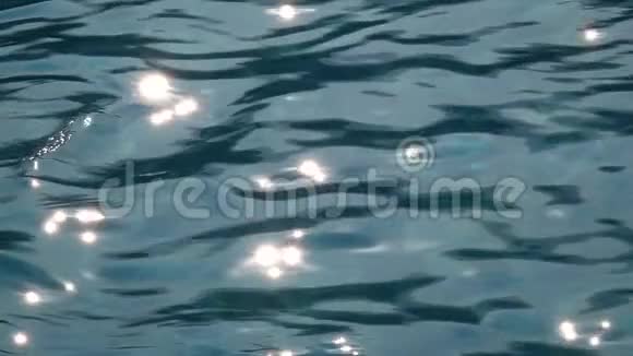 阳光反射在平静的海水清澈的蓝色水面上慢动作关门视频的预览图