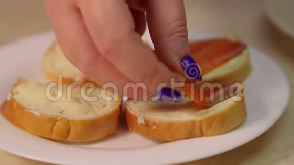 女人的手把红鱼片放在黄油三明治上视频的预览图