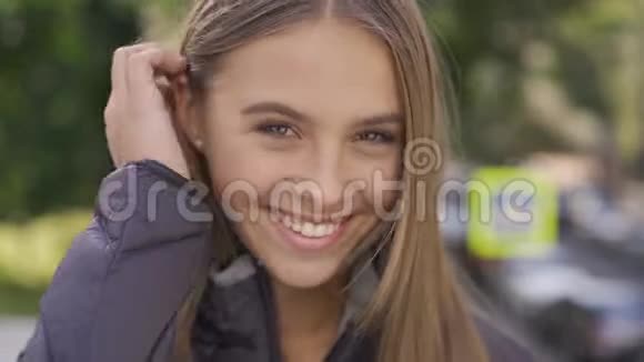 一位年轻迷人的白种人棕色长发幸福地看着镜头微笑情感幸福视频的预览图