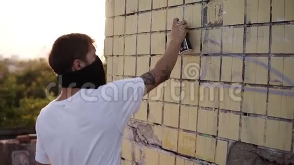城市街头艺术家正站在街道建筑墙附近用喷雾器喷漆作画现代艺术视频的预览图