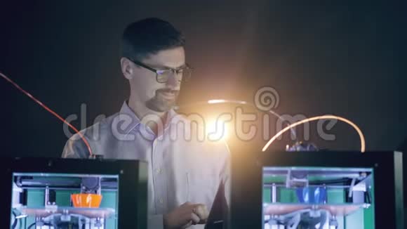 一个人在使用3D打印机时在平板电脑上打字视频的预览图