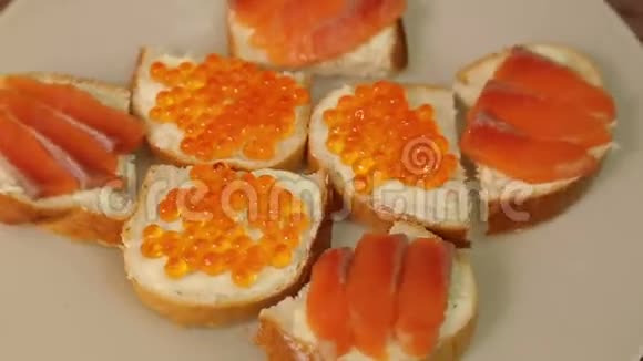 一盘带红鱼和红鱼子酱的三明治旋转成一圈视频的预览图
