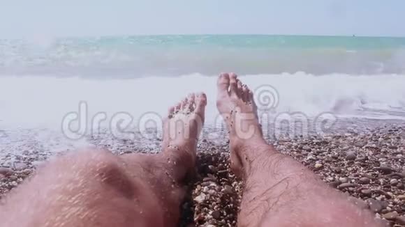 一个躺在海边的人的腿蓝色海洋背景上的男性腿一个人在一个视频的预览图