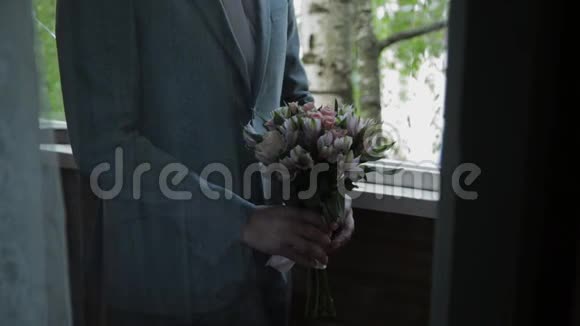一个手里拿着结婚花束的年轻人视频的预览图