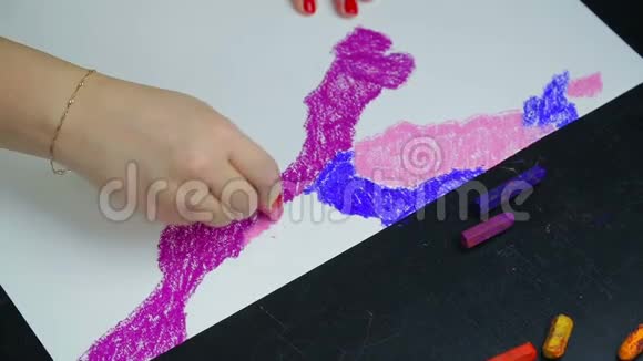 女人的手在白纸上用粉红色的粉彩画晚霞视频的预览图