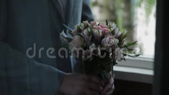 一个手里拿着结婚花束的年轻人视频的预览图