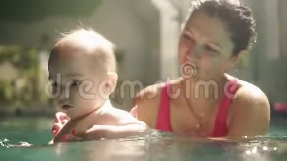 高兴的白种人母亲和她的小男孩正在室内游泳池里游泳在水下挥手儿童视频的预览图