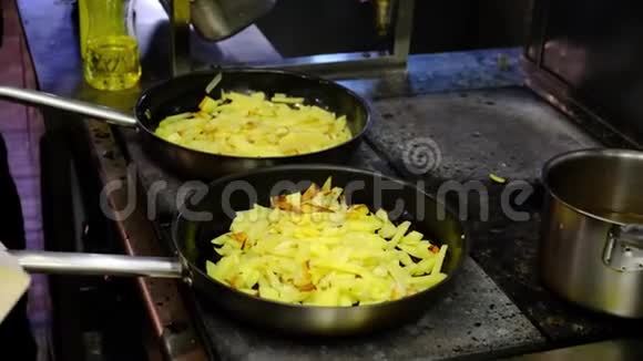 厨师积极在餐厅的厨房工作把炸土豆扔进锅里视频的预览图