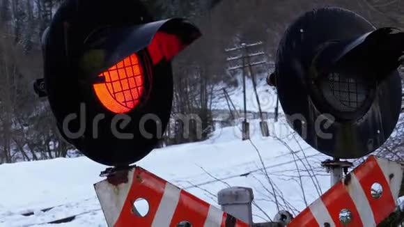 在冬季的一个森林里的铁路十字路口红色闪光交通灯列车通过视频的预览图