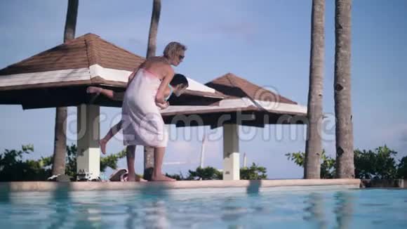 母亲把孩子扔在游泳池里暑假在度假酒店休息视频的预览图