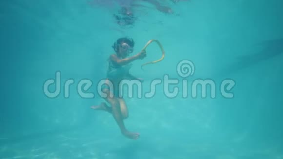 一个小女孩在水下游泳和玩蛇玩具视频的预览图