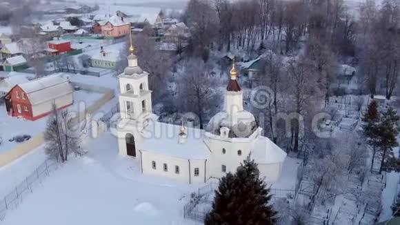 在一个晴朗的寒冷的天黎明时俯瞰一座古老的俄罗斯教堂无人驾驶飞机的全景射击视频的预览图