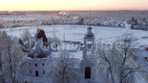 黎明时分在晴朗的霜天上鸟瞰古老的俄罗斯教堂视频的预览图
