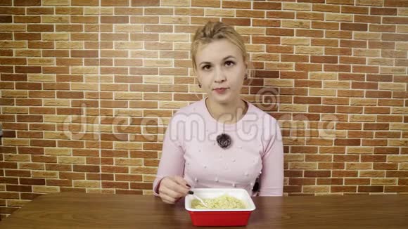 年轻女子在家吃方便面不健康的生活方式和饮食习惯饥饿的女孩指着垃圾食品视频的预览图