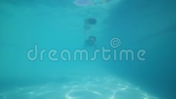 戴着潜水面罩的女孩正在水下游泳池里潜水俯瞰水底视频的预览图