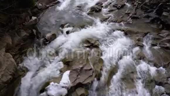 冬天的瀑布普鲁特从山溪和带雪的石急流中快速流出的水视频的预览图