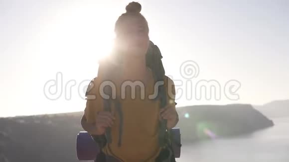 年轻无忧无虑的女孩带着背包在群山的映衬下沿着山顶湖散步夏季视频的预览图