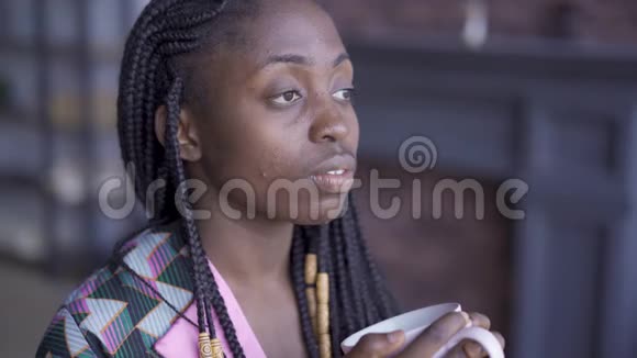 细致入微的非洲裔美国妇女的肖像画她的非洲辫子望着一边喝咖啡女孩视频的预览图