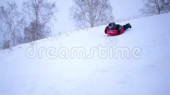 一个人骑着雪橇在雪山上慢动作雪的冬季景观户外运动视频的预览图