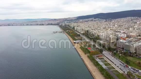 塞萨洛尼基市的城市海岸线建筑物和公园多云的天空冬天通过无人机前进视频的预览图