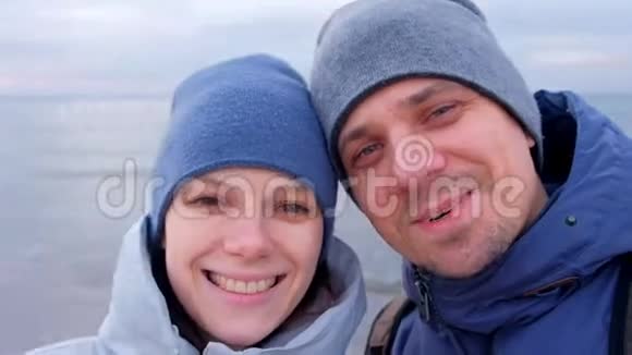 男人和女人的博客在自拍视频微笑和交谈在海上冬天视频的预览图