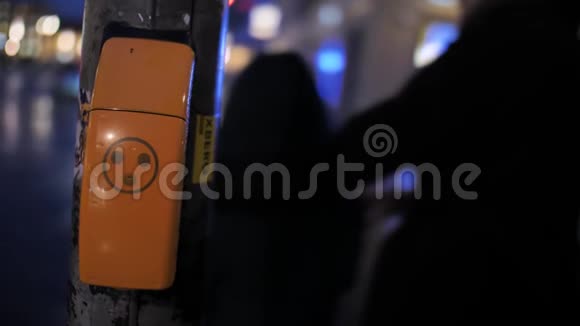 斑马线附近的人在晚上特写橙色按钮视频的预览图