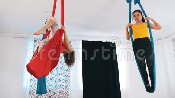 空中瑜伽两个女人在吊床上锻炼站在里面视频的预览图
