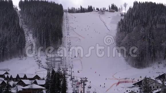 滑雪胜地滑雪者在阴天的雪坡上骑马布科维尔喀尔巴阡山视频的预览图