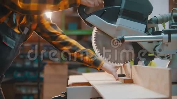 木工一名木工用一把锋利的圆锯切割木头视频的预览图
