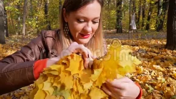漂亮的女人编织黄色的枫叶花环视频的预览图
