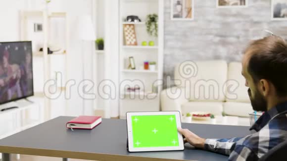 男人手里拿着一台绿色屏幕的数字平板电脑视频的预览图