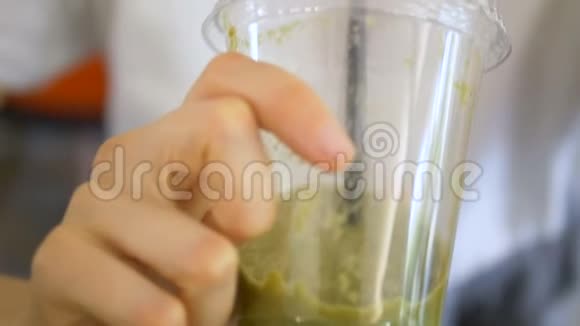 布鲁内特在透明塑料杯里尝起来是绿色新鲜的视频的预览图