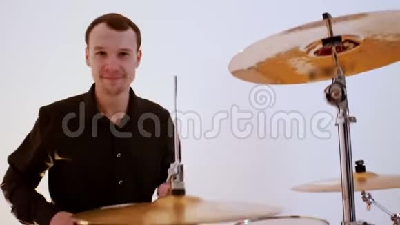 一个微笑的男子鼓手从音乐乐队演奏歌曲在工作室视频的预览图