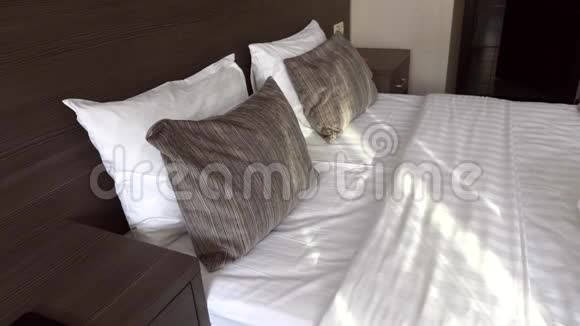 美丽的酒店客房配有带枕头的大床和新鲜的亚麻床视频的预览图