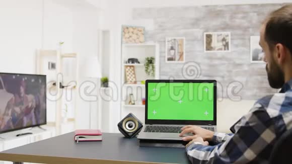 男人在绿色屏幕笔记本电脑上浏览互联网明亮而明亮视频的预览图