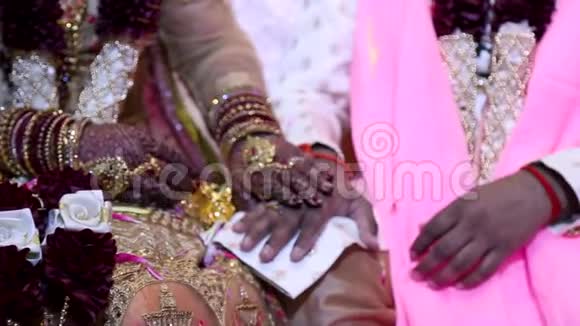 一对穿着传统婚礼服装的印度夫妇在印度婚礼上牵手的近镜头高清24FPS视频的预览图