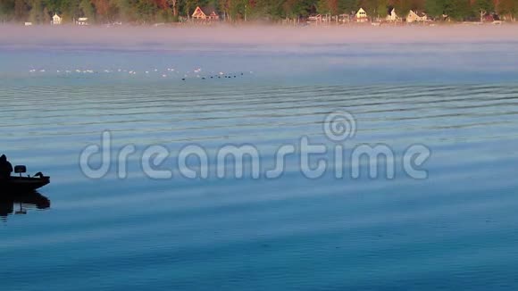 渔舟剪影在日出雾水的宁静的早晨经过视频的预览图